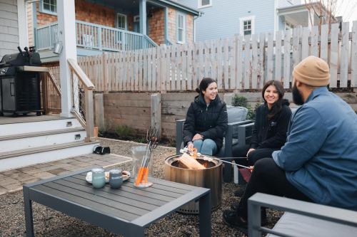 Un gruppo di persone seduti intorno a un tavolo in un cortile di Good Day Getaway by Seabrook Hospitality a Pacific Beach