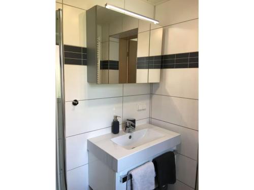 a bathroom with a white sink and a mirror at Ferienhaus Hahndorf in Goslar