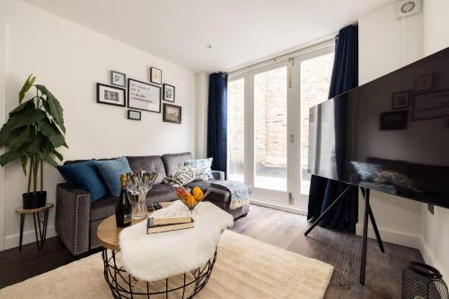 a living room with a couch and a table at Wild Roses Serviced Apartments - Chelsea in London