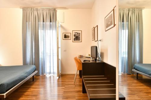 a bedroom with a bed and a desk with a computer at Donna Eleonora Residence in Matera