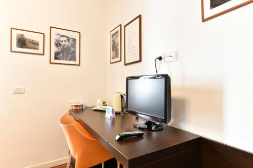 a desk with a computer monitor on top of it at Donna Eleonora Residence in Matera