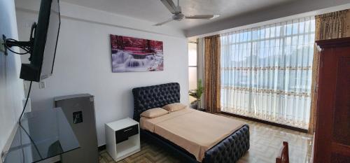 ein kleines Schlafzimmer mit einem Bett und einem TV in der Unterkunft Makasai Habitaciones in Puerto Maldonado