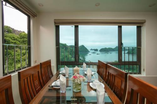 a dining room with a table with a view of the water at Dung Boutique Inn in Cat Ba