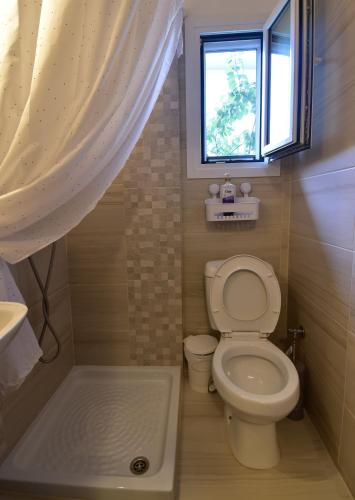 a small bathroom with a toilet and a window at Magenta in Igoumenitsa