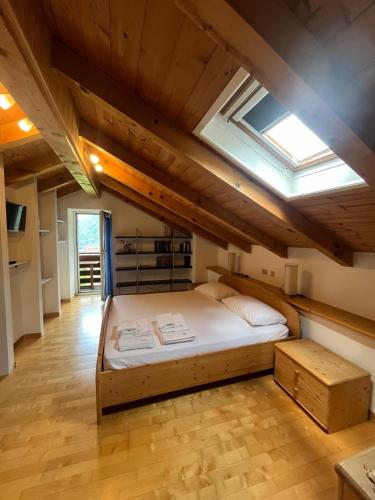 a bedroom with a large bed with a skylight at Casa Valsugana Lagorai in Roncegno