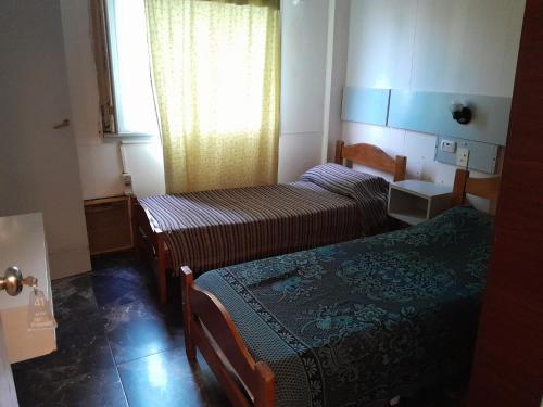 a small room with two beds and a window at Hotel PANAME, CERCA DE LA RURAL , EMBAJADA EEUU , HIPÓDROMO DE PALERMO Y CAMPO DE POLO in Buenos Aires