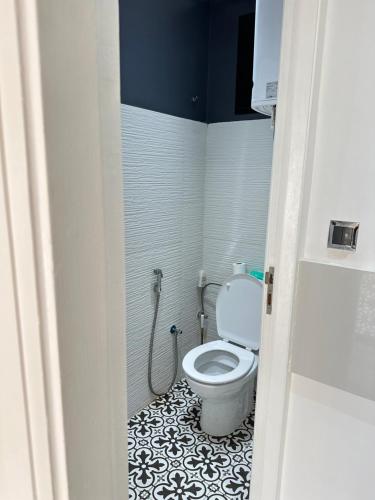 a bathroom with a toilet with a black and white tile floor at Chambre à Agdal Rabat dans un appartement partagé -two single beds- in Rabat