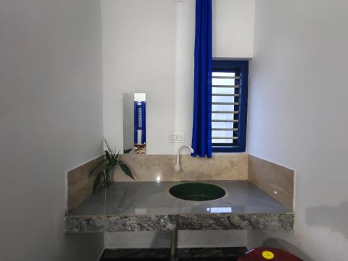 a bathroom with a sink and a window at Johns Villa in Sultan Bathery