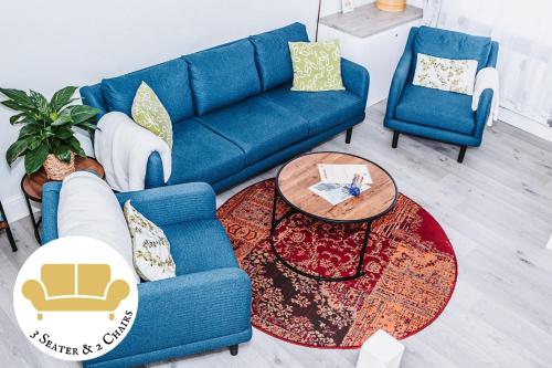 a blue couch and two chairs in a living room at Enjoy the Pause in the heart of Chester -free parking, 2 min walk to shops, river, cafes & direct trains to Liverpool & Manchester in Chester