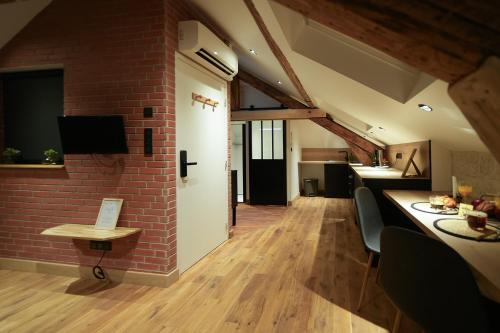 a kitchen and living room with a brick wall at Evasion chic, spa et sauna sous les toits in Nancy