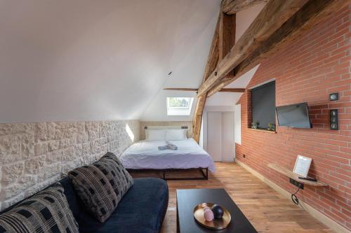 a room with a bed and a couch in a room at Evasion chic, spa et sauna sous les toits in Nancy