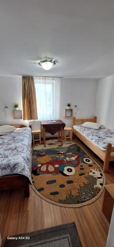 a room with two beds and a pool table at Pensiunea Rustica La Avram Lunca Ilvei in Lunca Ilvei