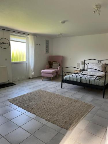 a bedroom with a bed and a chair and a rug at Bei Hempels in Breitscheid