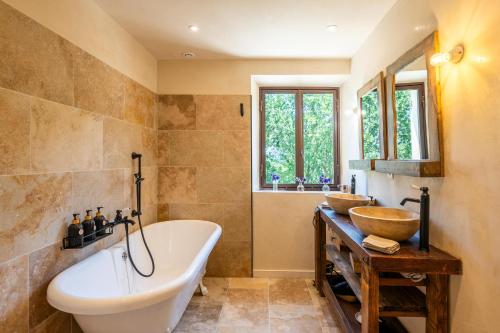 a bathroom with a tub and two sinks in it at Bastide de l'Orme à Ménerbes avec vue Luberon in Ménerbes