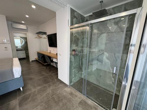 a bathroom with a shower and a bed and a television at Naxos Marina Bay in Giardini Naxos
