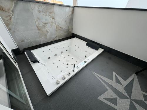 a bathtub in a room with a glass wall at Naxos Marina Bay in Giardini Naxos