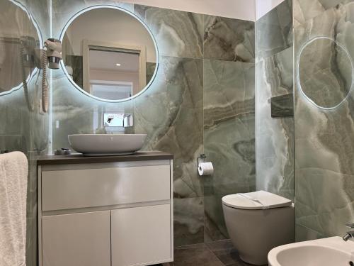 a bathroom with a sink and a toilet and a mirror at Naxos Marina Bay in Giardini Naxos