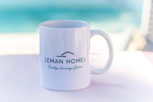 une tasse à café blanche avec une photo d'une maison dans l'établissement Villa du Leman, à Thonon-les-Bains