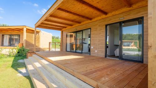 a wooden deck with glass doors on a house at Agricamping Ai Prati in Lazise