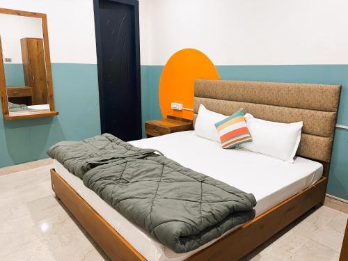 een slaapkamer met een bed met een oranje en blauwe muur bij Madpackers Rishikesh Ganga View in Rishīkesh