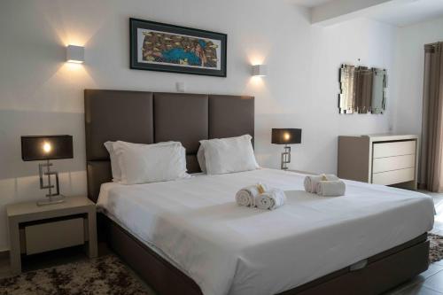 una camera da letto con un grande letto bianco con asciugamani di Vilas Marrocha a Porches