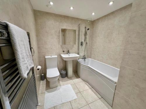 倫敦的住宿－Mayfair Piccadilly Apartment 5，浴室配有卫生间、盥洗盆和浴缸。