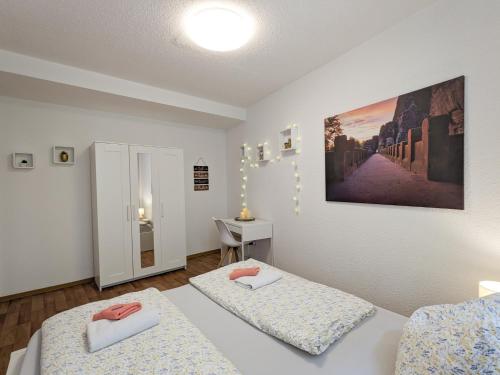 a room with two beds and a table in it at HW1B - Urlaubsmagie Gemeinschaftsgarten mit Pool, Sauna & Terrasse in Sebnitz