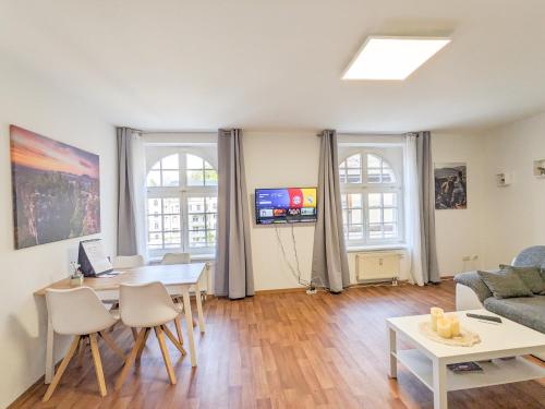 a living room with a table and a couch at HW1B - Urlaubsmagie Gemeinschaftsgarten mit Pool, Sauna & Terrasse in Sebnitz