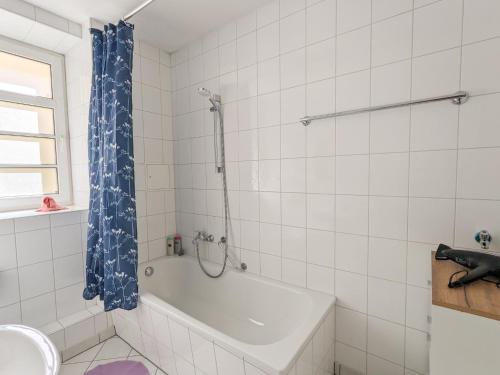 a white bathroom with a tub and a shower at HW1B - Urlaubsmagie Gemeinschaftsgarten mit Pool, Sauna & Terrasse in Sebnitz