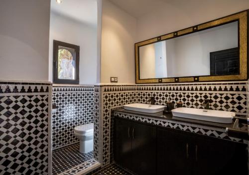 a bathroom with two sinks and a mirror at Riad Tamazgha in Marrakesh