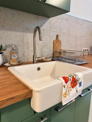 a white kitchen sink with a towel on it at Gite Bulle Appart' 1 in Épernay