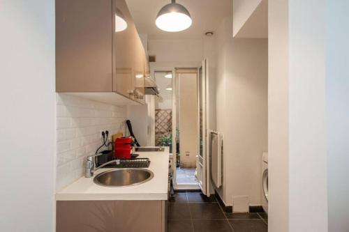 une cuisine avec un évier et un plan de travail dans l'établissement Appartement centre Levallois Proche Paris, à Levallois-Perret