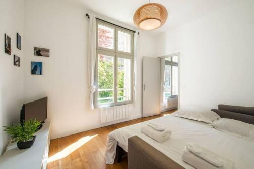 - une chambre blanche avec un lit et un canapé dans l'établissement Appartement centre Levallois Proche Paris, à Levallois-Perret