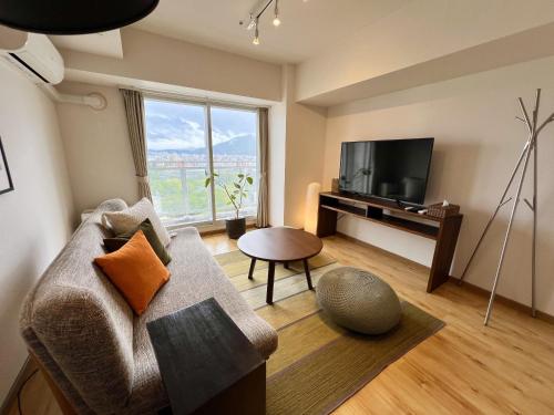 a living room with a couch and a television at AMSタワー中島 in Sapporo