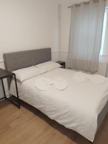 a bedroom with a bed with white sheets and a window at City Guest House se1 in London