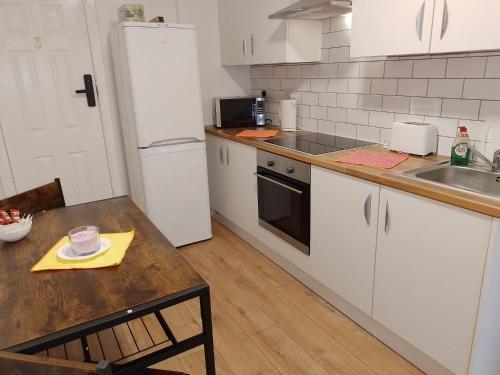 a kitchen with a table and a white refrigerator at City Guest House se1 in London