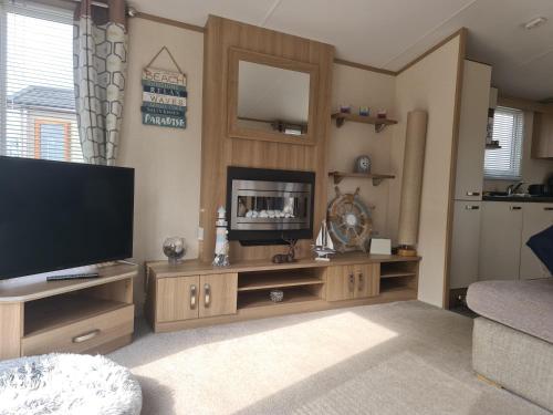 FeltonにあるFern Lodge Holiday Lets presents Ruby Lodgeの大型薄型テレビのあるリビングルーム