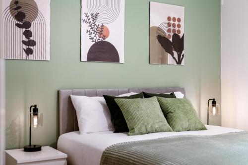 a bedroom with a bed with green and white pillows at STN - Bishops's Stortford - Free Gated Parking - Two Bed Apartment - Perfect location for Stansted Airport in Bishops Stortford