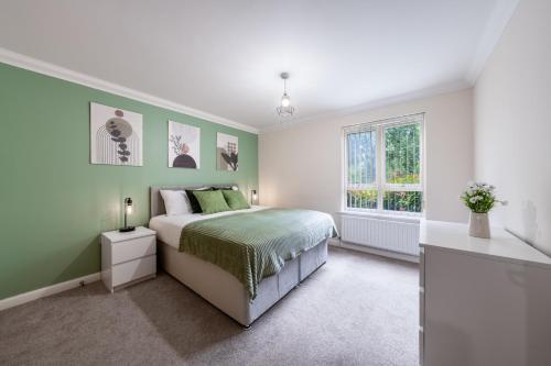 a bedroom with green and white walls and a bed at STN - Bishops's Stortford - Free Gated Parking - Two Bed Apartment - Perfect location for Stansted Airport in Bishops Stortford