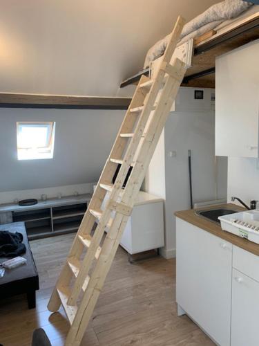 une échelle en bois dans une cuisine à côté d'un comptoir dans l'établissement Le studio de la plage !, à Dunkerque