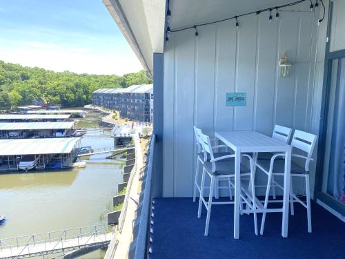a balcony with a table and chairs and a river at B Lakefront! Remodeled, Boat Slip, Patio Views, Pool, Boat Ramp, WIFI in Osage Beach