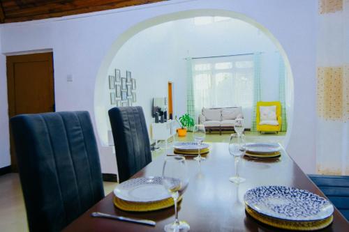 una sala da pranzo con tavolo e bicchieri da vino di Winnie's Cozy Home a Iringa