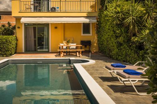 a pool with chairs and a table and a house at Villa Siora Anna in Skala