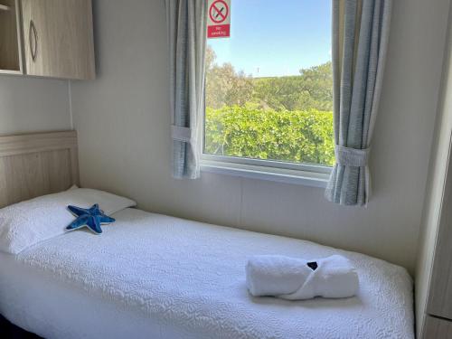 a small bedroom with a bed with a window at Newquay Bay Resort Sandy Toes - Hosting up to 6 in Newquay