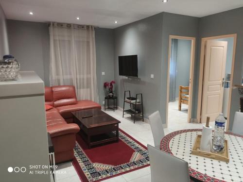 a living room with a couch and a table at Charmante maison 4 personnes proche de paris in Carrières-sous-Poissy