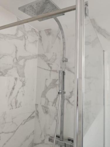 une douche avec une porte vitrée dans une salle de bain dans l'établissement Charmante maison 4 personnes proche de paris, à Carrières-sous-Poissy