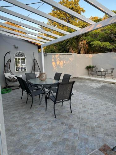 a patio with a table and chairs under a pergola at Altera Vita in Agía Zóni