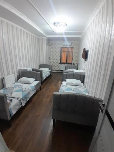 a room with three beds and couches in it at Delfin Hotel & Restaurants & Spa in Ganja