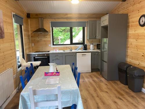 a kitchen with a table and chairs in a cabin at Rosies Cabin Maum in Galway