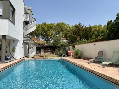 une piscine dans l'arrière-cour d'une maison dans l'établissement Studio Val de Naurouze Piscine Parking, à Colomiers